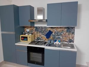 a kitchen with blue cabinets and a stove top oven at HOUSE MAGIE 2 e 3 in Marco Simone