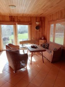 a living room with a table and chairs and a couch at Elniaragio Guolis 