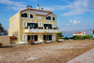 a large yellow building on top of a hill at Vasilaras Hotel in Skala