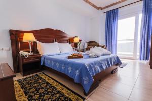 1 dormitorio con 1 cama grande con manta azul en Kymata, en Paralia Katerinis
