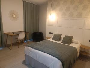 Schlafzimmer mit einem Bett, einem Tisch und einem Schreibtisch in der Unterkunft Hotel Cedran in Granada