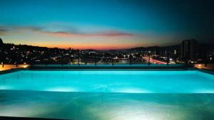 uma grande piscina à noite com uma cidade em Escenia Loft Deluxe em Guadalajara