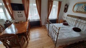 sypialnia ze stołem i łóżkiem oraz drewnianą podłogą w obiekcie Zlatá léta - apartmánový dům Jáchymov w mieście Jáchymov