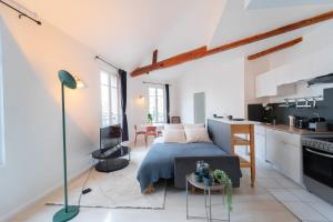 a bedroom with a bed and a small kitchen at Appartement Porte de Versailles in Malakoff