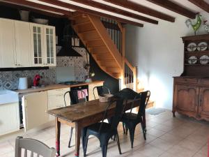 a kitchen with a wooden table and chairs at Le gîte du Bois de Sanzay in Saint-Martin-de-Sanzay