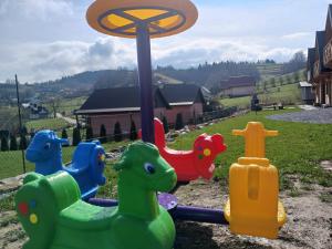 a playground with colorful play equipment in a yard at Motylowe Wzgórze Zawóz Bieszczady in Zawóz