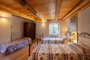 Madonna del SassoにあるDal Picasass Houseの木製の天井が特徴のベッドルーム1室(ベッド2台付)