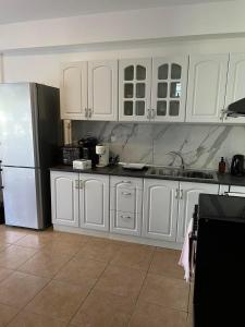 una cucina con armadietti bianchi e frigorifero di Peaceful Escape a Kavala