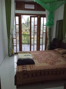 a bedroom with a bed and a large window at WATHSALA HOME VILLA(homestay) in Ella