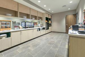a large kitchen with a counter and a cafeteria at Home2 Suites By Hilton Tulsa Airport in Tulsa