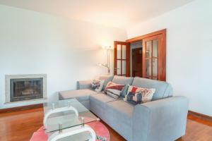 a living room with a blue couch and a fireplace at Apartment Qian Rio Douro porto in Porto