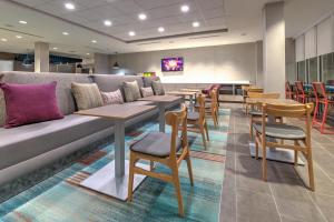 a waiting room with tables and a couch and chairs at Home2 Suites By Hilton Tulsa Airport in Tulsa