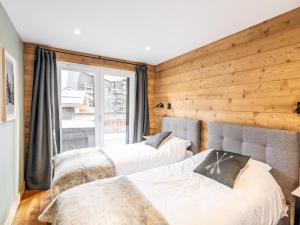 2 camas en una habitación con pared de madera en Appartement Les Deux Alpes, 4 pièces, 10 personnes - FR-1-546-49, en Les Deux Alpes