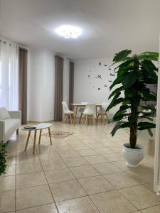 un salon avec une table et une plante en pot dans l'établissement Alemà casa vacanze, à Leporano