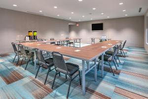 una gran sala de conferencias con una mesa larga y sillas en Home2 Suites By Hilton Tulsa Airport en Tulsa