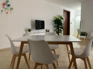 a dining room with a white table and chairs at Alemà casa vacanze in Leporano