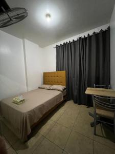 a bedroom with a bed and a table with a tableablish at Hospedaje Senegal cerca al aeropuerto in Lima