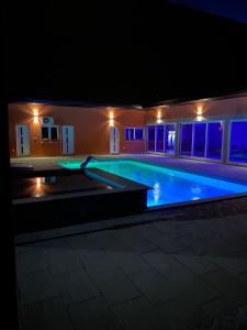 a swimming pool lit up at night at Vikendica za odmor Laktasi in Laktaši