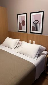 sypialnia z łóżkiem z dwoma obrazami na ścianie w obiekcie Castelo Inn Hotel w mieście Goiânia