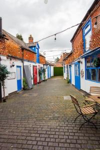 a cobblestone alley with a bench and buildings at The Piano Cottage in a Beautiful Medieval Town in Market Bosworth