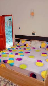 Una cama grande con lunares de colores. en Chic minontin, en Cotonou