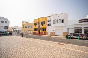 an empty street with buildings and a parking lot at Casa Checa Apartment 3 in El Cotillo +11 photos