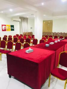 a conference room with a red table and chairs at قصائد in Salalah