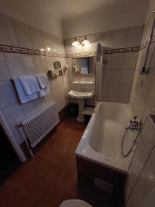 uma casa de banho com uma banheira branca e um lavatório. em Hotel Apartment Rothensteiner em Viena