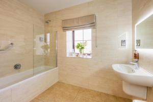 uma casa de banho com um lavatório, uma banheira e um WC. em Flagstaff Lodge em Newry