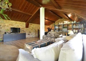 a living room with a couch and a tv at A Casa de Suárez in Negreira