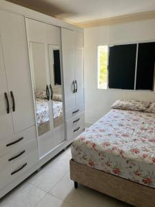 una camera da letto con armadi bianchi, un letto e una finestra di Ap202 Vista Praia de Bicanga a Serra