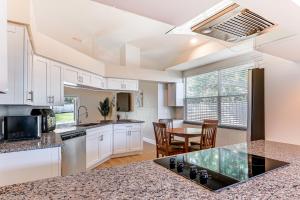 a kitchen with white cabinets and a table with chairs at Valrico Home with Yard about 14 Mi to Downtown Tampa in Valrico