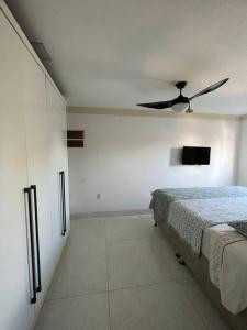 Ap202 Vista Praia de Bicanga في سيرا: غرفة نوم بسرير ومروحة سقف