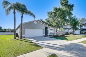 a house with a palm tree and a garage at Valrico Home with Yard about 14 Mi to Downtown Tampa in Valrico