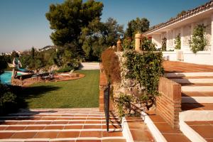 a backyard of a house with a brick wall at 7,000 sqm Luxurious Villa with Panoramic Sea Views Multiple Gardens & Two Pools in Benalmádena