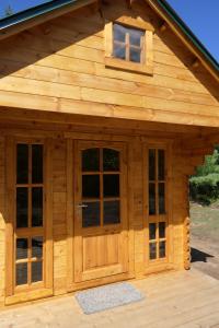 a log cabin with a large wooden door and windows at Deer Meadow #1 in Maynooth