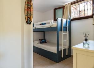 Habitación pequeña con litera y tabla de surf en Vacanza in ambiente esclusivo. en Simius