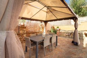 stół i krzesła pod parasolem na patio w obiekcie Vacanza in ambiente esclusivo. w mieście Villasimius