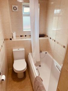 a bathroom with a toilet and a tub and a sink at 2 bedroom house walking distance to city centre WITH FREE PARKING in York