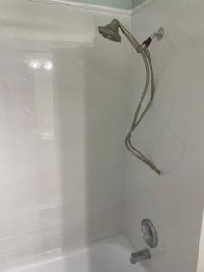 La salle de bains est pourvue d'une douche avec un pommeau de douche. dans l'établissement Sunset Retreat, à Bradenton