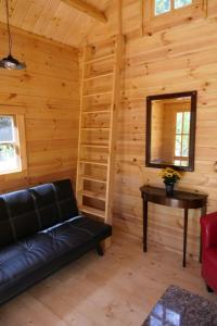 a living room with a couch and a table in a log cabin at Deer Meadow #1 in Maynooth