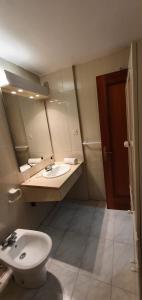 uma casa de banho com um lavatório, um WC e um espelho. em Complejo Vallsun em Estepona