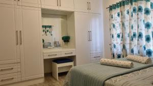 ein Schlafzimmer mit einem Bett, einem Waschtisch und einem Spiegel in der Unterkunft 2BR Cottage Swimming Pool Near Airport in Harare