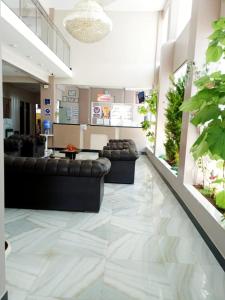 a lobby with black leather couches and plants at The Oruro Inn in Oruro