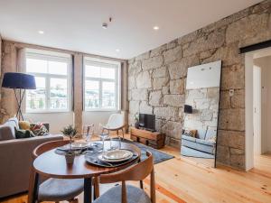 a living room with a table and a stone wall at Porto River in Porto