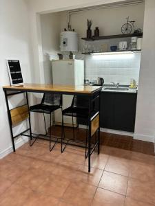 a kitchen with a table with chairs and a refrigerator at Monoambiente/Studio Avenida Gaona Ramos Mejía in Ramos Mejía