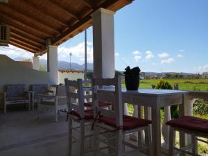 a table and chairs on a patio with a view of a field at natura studios superior almyros in Almiros Beach