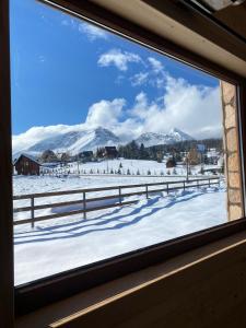 a window with a view of snow covered mountains at Portes du Soleil - Zabljak in Žabljak