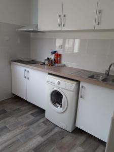 een keuken met een wasmachine en een wastafel bij 143 VH in Le Blanc-Mesnil