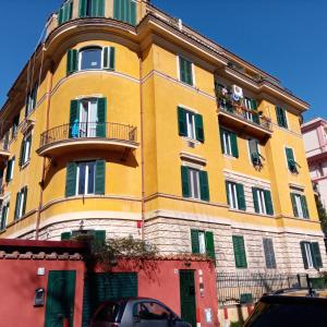 un edificio giallo con balcone sul lato di ANDENIS TIBER HOUSE a Roma